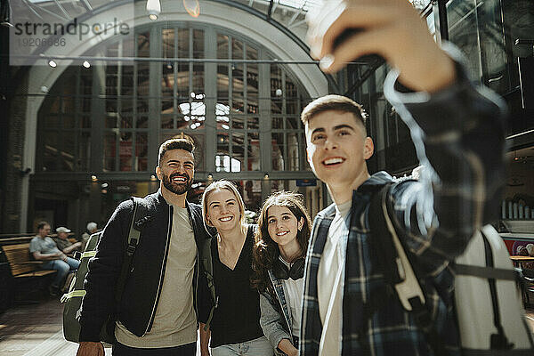 Fröhliche Familie macht gemeinsam ein Selfie  während sie am Bahnhof steht