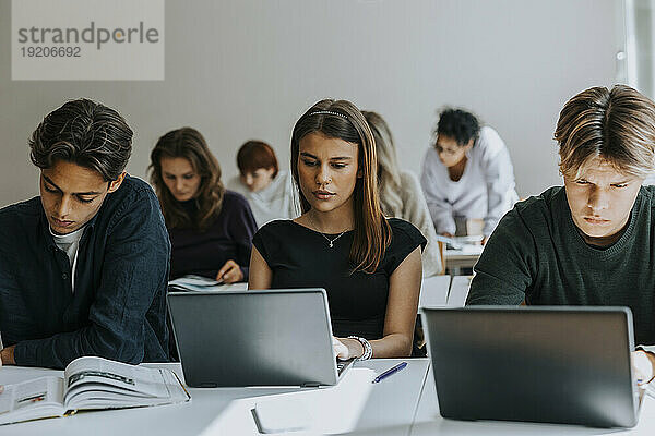 Gemischtrassige Teenager lernen am Schreibtisch im Klassenzimmer