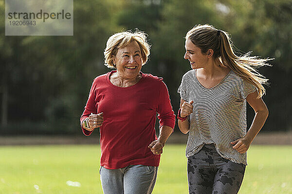 Enkelin und Großmutter haben Spaß beim gemeinsamen Joggen im Park