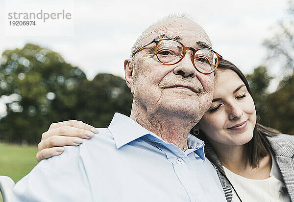 Porträt eines selbstbewussten älteren Mannes mit seiner Enkelin in einem Park