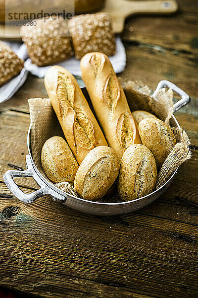 Two baguettes and four rye bread rolls in a pot