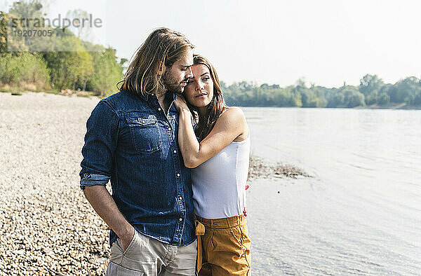 Junges verliebtes Paar am Flussufer