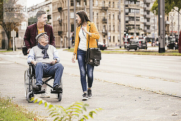 Älterer Mann im Rollstuhl verbringt Zeit mit seinen Enkelkindern