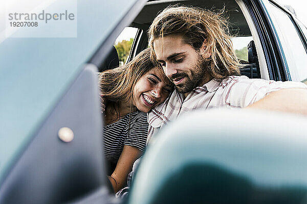 Glückliches junges Paar in einem Auto