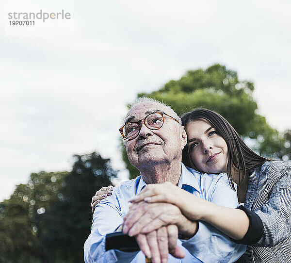 Porträt eines älteren Mannes und seiner Enkelin in einem Park