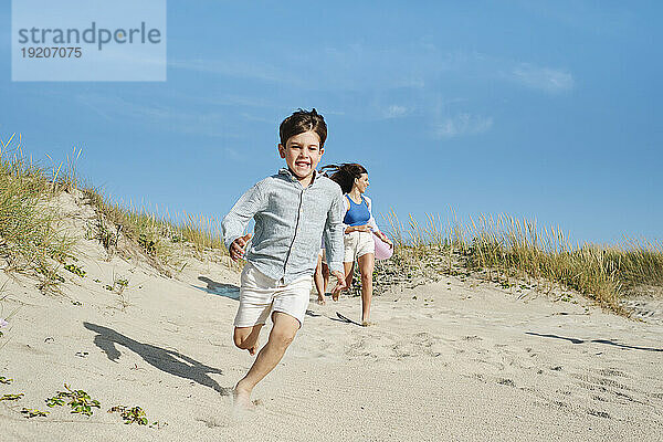 Familie läuft und genießt an einem sonnigen Tag am Strand