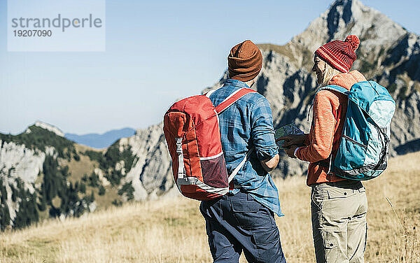 Österreich  Tirol  Paar mit Karte beim Wandern in den Bergen