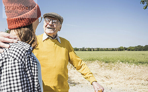 Glücklicher älterer Mann mit Enkelin an einem sonnigen Tag