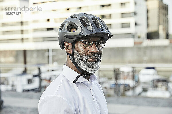 Porträt eines reifen Geschäftsmannes mit grauem Bart  Fahrradhelm und Brille
