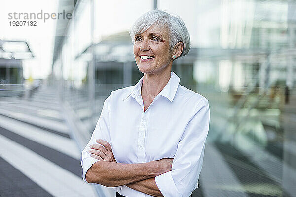Lächelnde ältere Geschäftsfrau schaut sich draußen um