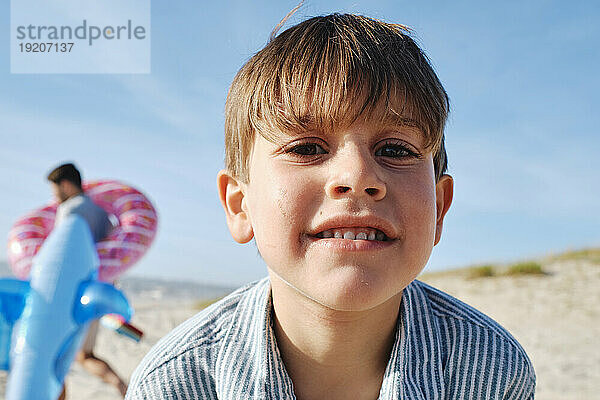 Glücklicher blonder Junge am Strand an einem sonnigen Tag