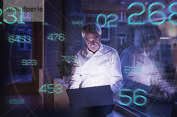 Futuristische Zahlen bewegen sich in Richtung eines leitenden Geschäftsmannes  der im Büro am Laptop arbeitet