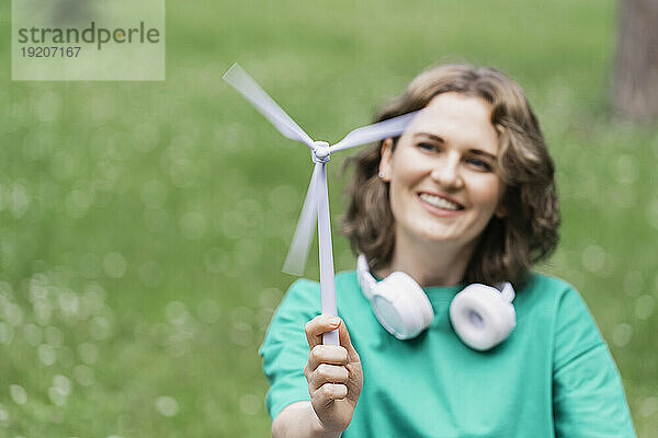 Lächelnde Frau hält Windturbinenmodell