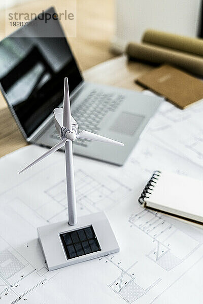 Windturbinenmodell  Bauplan und Laptop auf dem Tisch im Büro