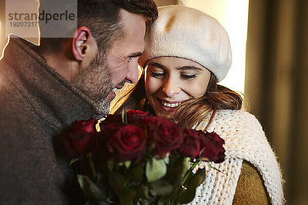 Verliebtes Paar mit einem Strauß roter Rosen im Winter