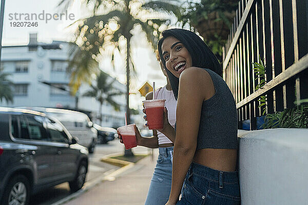 USA  Florida  Miami Beach  two happy female friends having a soft drink in the city
