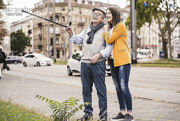 Älterer Mann und erwachsene Enkelin erkunden die Stadt