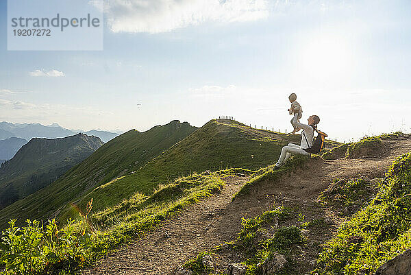 Germany  Bavaria  Oberstdorf  mother and little daughter on a hike in the mountains having a break