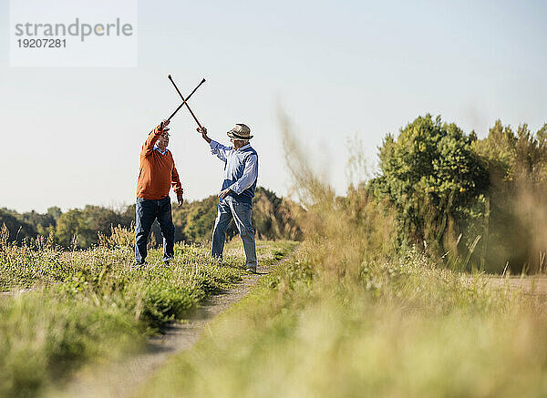 Zwei alte Freunde  die mit ihren Spazierstöcken die Felder einzäunen