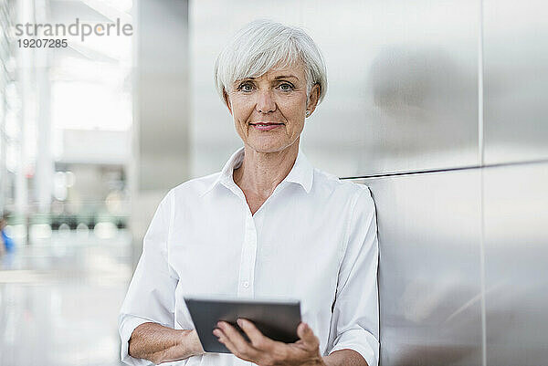 Porträt einer lächelnden älteren Geschäftsfrau mit Tablet