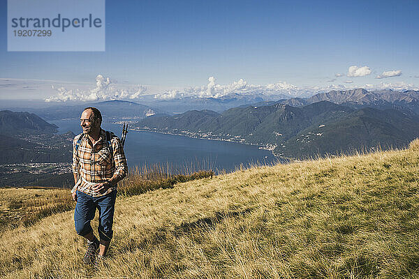 Mature man exploring mountain at sunny day