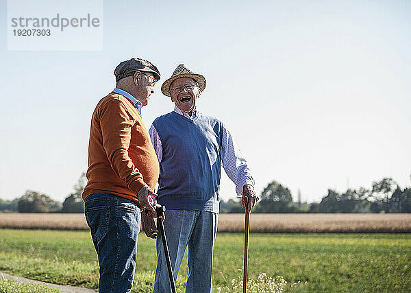 Zwei alte Freunde stehen auf den Feldern und reden über alte Zeiten