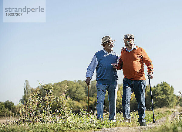 Zwei alte Freunde machen einen Spaziergang durch die Felder und reden über alte Zeiten