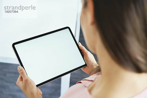 Close up of woman holding tablet in office