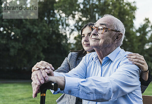 Porträt eines älteren Mannes mit seiner Enkelin in einem Park