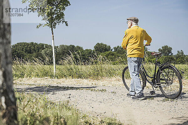 Aktiver älterer Mann  der mit dem Fahrrad auf der Straße unterwegs ist