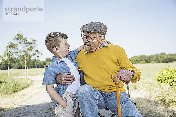 Glücklicher Junge mit Großvater auf dem Feld
