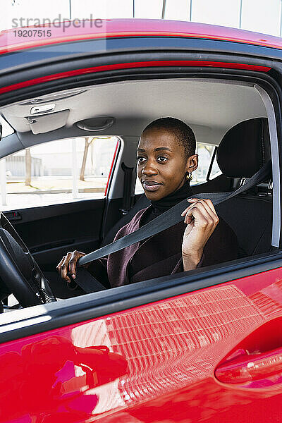 Nachdenkliche Frau passt den Sicherheitsgurt im Auto an