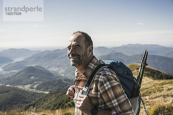 Smiling hiker with backpack at sunny day