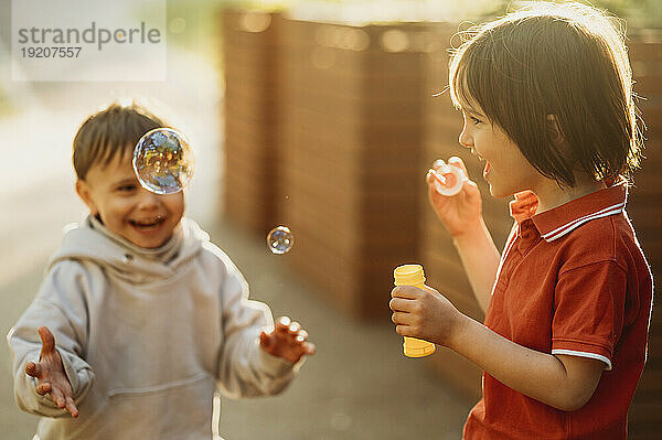 Happy brothers playing with soap bubbles