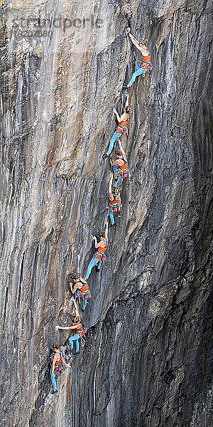 Frau klettert mit Seil auf felsigen Berg