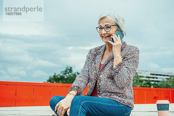 Ältere Geschäftsfrau spricht am Smartphone