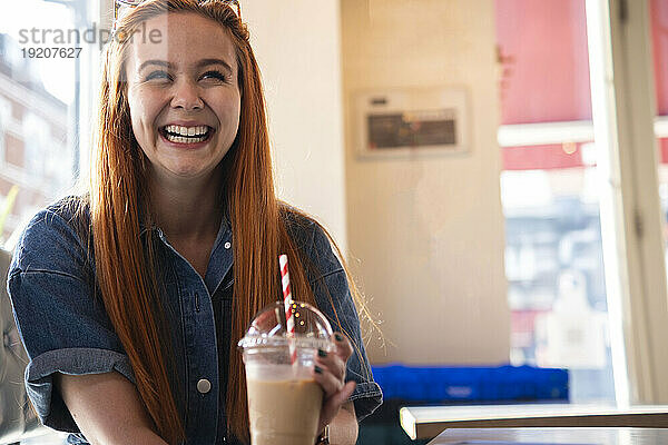 Glückliche Geschäftsfrau mit Kaffee im Café