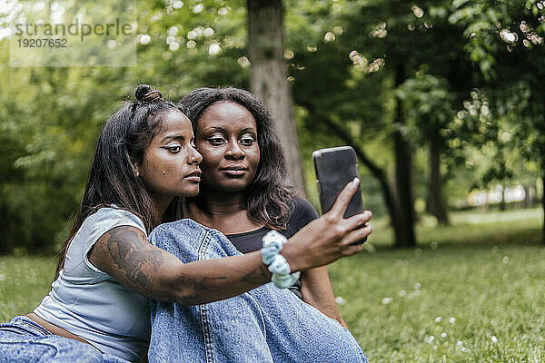Young friends taking selfie at park