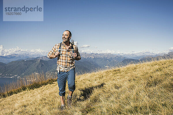 Happy hiker walking on grass at sunny day