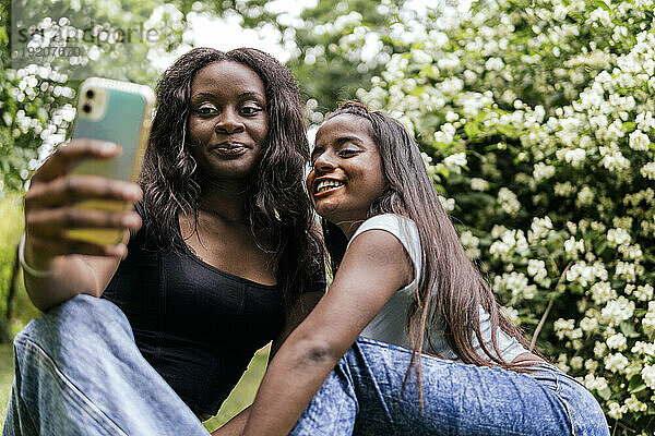 Glückliche Frauen machen Selfie im Park