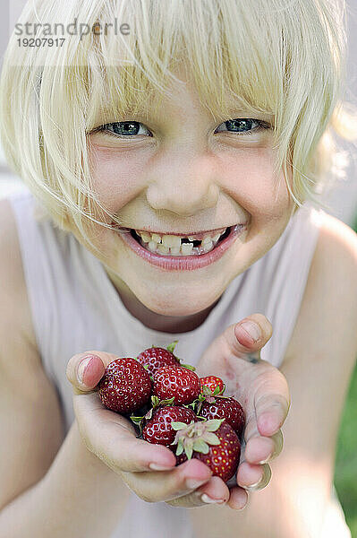 Lächelndes Mädchen mit frischen Erdbeeren