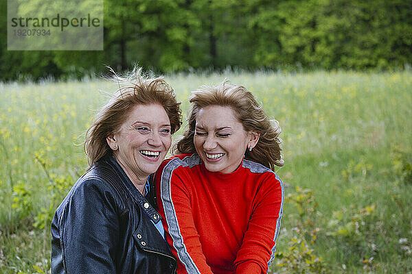Glückliche Mutter und Tochter lachen im Feld