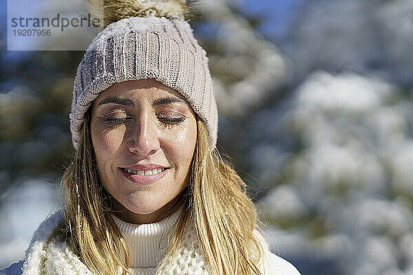 Schöne Frau mit geschlossenen Augen im Winter
