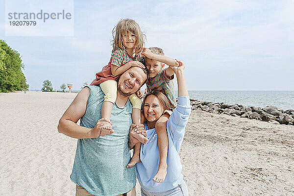 Lächelnde Familie  die Spaß am Strand hat