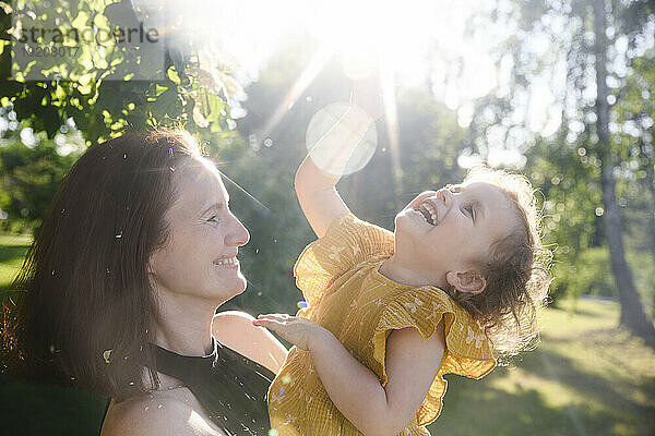Glückliche Mutter genießt es mit ihrer fröhlichen Tochter im Park