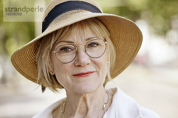 Ältere Frau mit Brille und Hut im Park