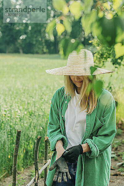 Frau mit Hut und Handschuhen im Garten