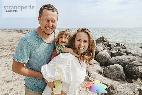 Glückliche Familie  die Spaß mit Tochter am Strand hat