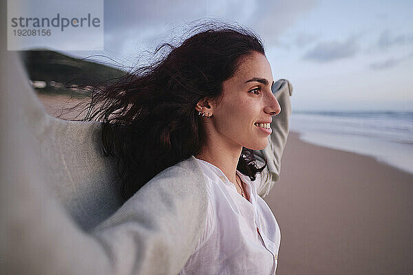 Lächelnde Frau verbringt ihre Freizeit am Strand