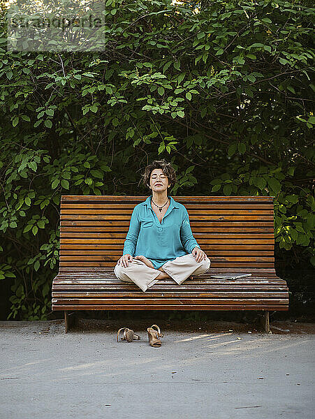 Lächelnde Geschäftsfrau meditiert im Büropark